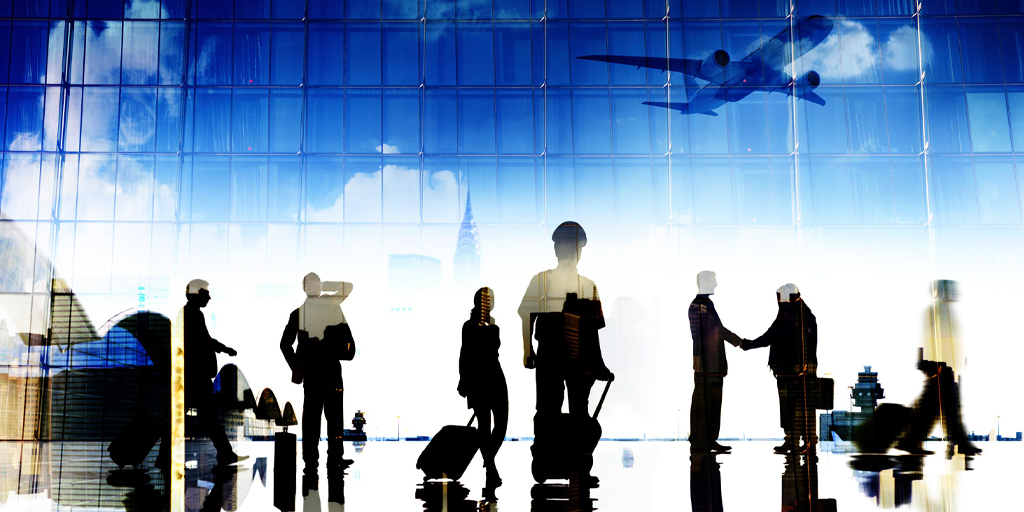 Shadowed images of people walking through an airport. A plane takes off in the background.
