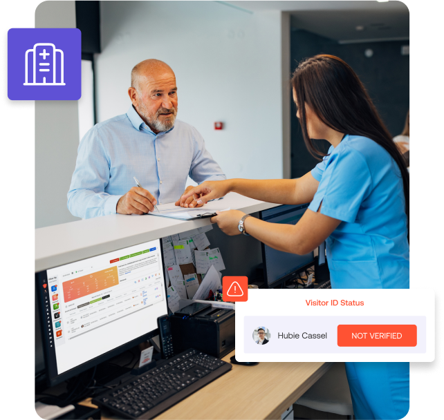 A man signs a document at a reception desk, assisted by a woman in scrubs. A computer screen flashes an alert: Visitor ID Status: Not Verified for Hubie Cassel, highlighting the need for compliant visitor management.