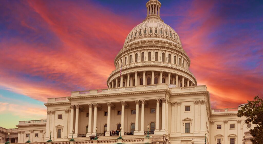 The U.S. Capitol building with a dramatic sunset sky in the background.