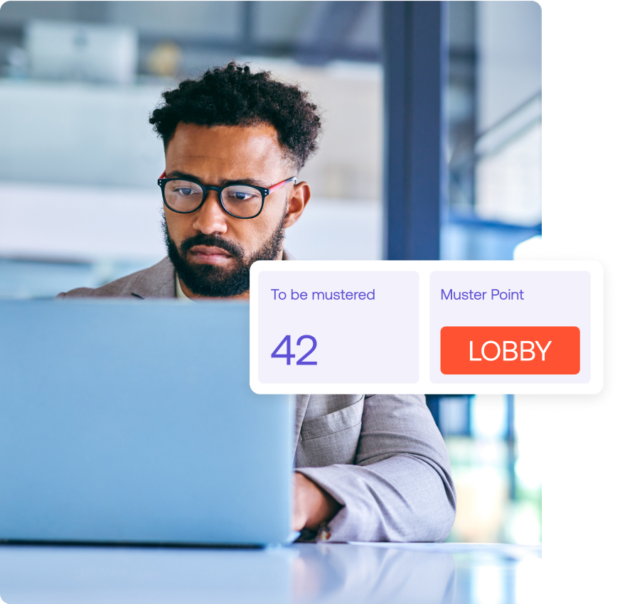 Man in glasses using a laptop with a notification showing To be mustered: 42 and Muster Point: Lobby.