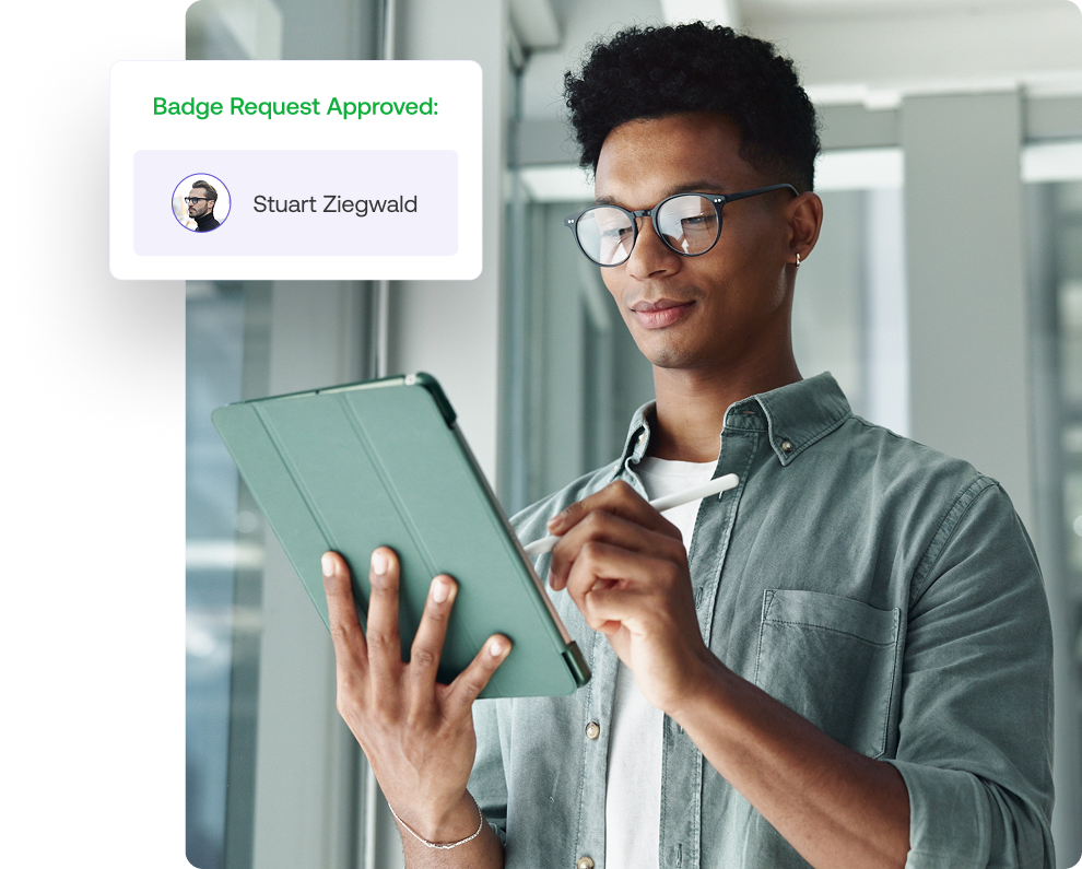 Person with glasses using a tablet. Notification on the side displays Badge Request Approved: Stuart Ziegwald.