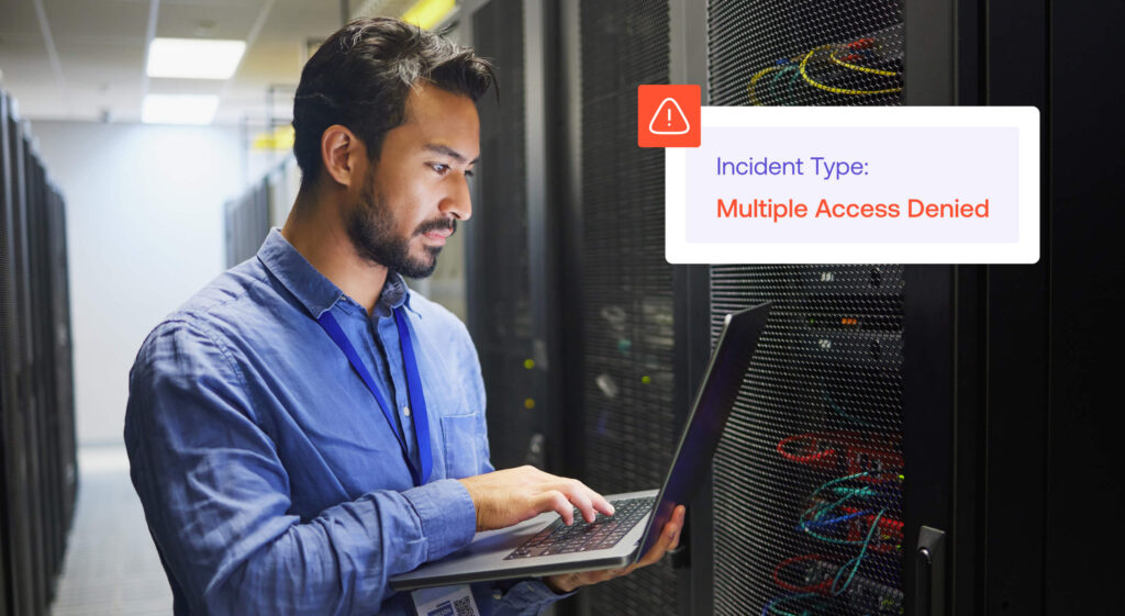 A person in a server room works on a laptop. A warning on the screen reads Incident Type: Multiple Access Denied.