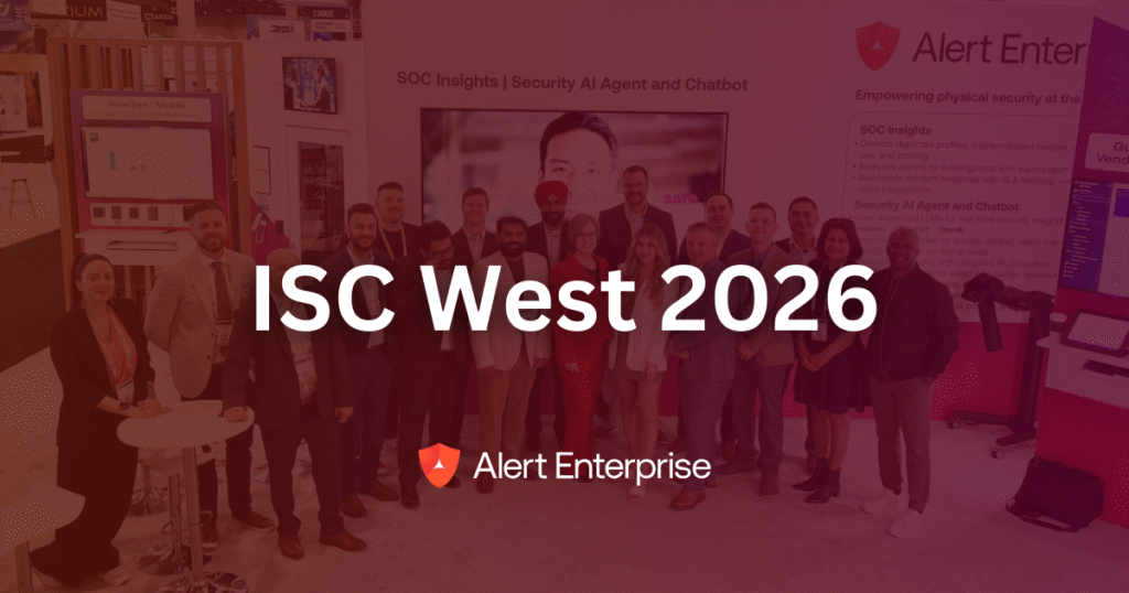 A group of people standing and posing at the Alert Enterprise booth at ISC West 2026, with event branding and displays in the background.